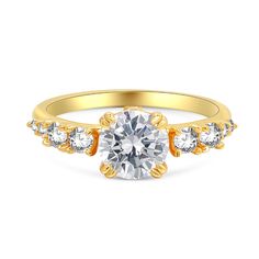 a yellow gold engagement ring with three stones on the band and a round center stone