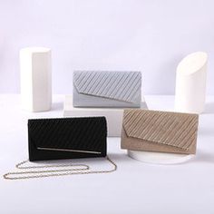 four different types of purses sitting on top of a white table next to each other