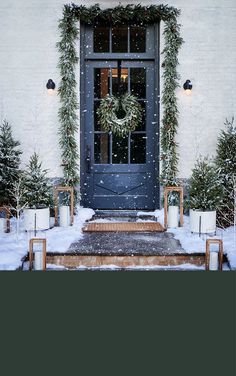 the front door is decorated with wreaths and christmas trees