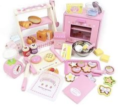 a pink toy kitchen set with lots of food and cooking utensils on the counter