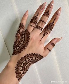 a woman's hand with henna tattoos on it