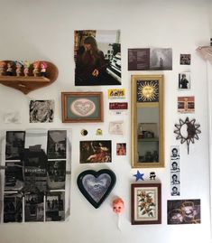 the wall is covered with many different pictures and framed objects, including hearts, photos, and other items