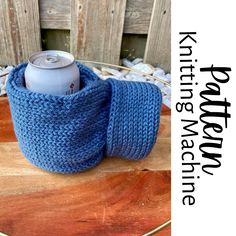 a blue knitted cup cozying on top of a wooden table