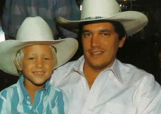 a man sitting next to a little boy wearing a cowboy hat