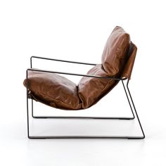 a brown leather chair sitting on top of a metal frame