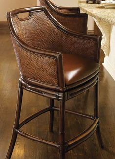 a brown chair sitting on top of a hard wood floor next to a white counter