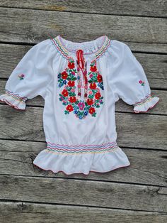 Handmade, hand embroidered and hand smocked folkblouse, Hungarian  Hand Embroidered blouse. Amazing embroidery Lenght 26 inch Bust : 43 - 44inch Peasant Blouse With Embroidered Border For Festivals, Traditional Embroidered Hem Blouse For Spring, Fitted Peasant Embroidered Top With Floral Details, Traditional Embroidered Blouse For Spring, Folk Style Peasant Top With Multicolor Embroidery, Peasant Top With Multicolor Embroidery And Embroidered Hem, White Peasant Top With Floral Embroidery, Multicolor Embroidered Peasant Top, Handmade White Folk Style Top