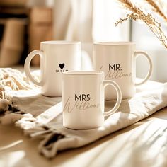 three white coffee mugs with mr and mrs written on them sitting on a table