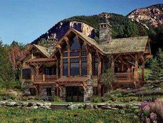 a large log cabin style house in the mountains