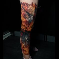 a man's leg with an eagle and fire tattoo on his arm, in front of a black background