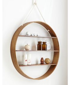 a circular wooden shelf with three shelves on each side and coffee mugs in the middle