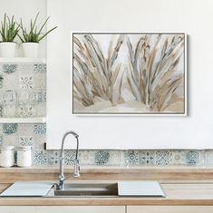 a kitchen sink under a painting on the wall