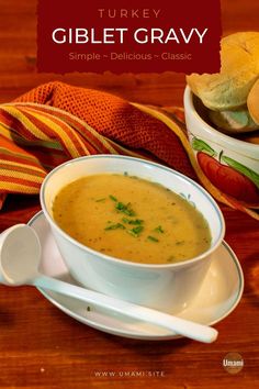 there is a bowl of soup with bread on the side and a spoon next to it