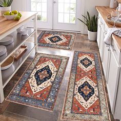 three rugs in the middle of a kitchen with fruit on the counter and plates