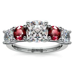 three stone engagement ring with red and white stones on the band, set in 18k white gold