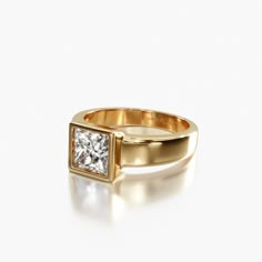 a gold ring with a princess cut diamond in the center, on a white background