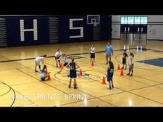 some girls are playing basketball in a gym with cones on the floor and one girl is holding a ball