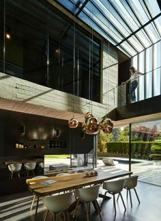 a dining room table and chairs in front of a large glass wall with an open floor plan