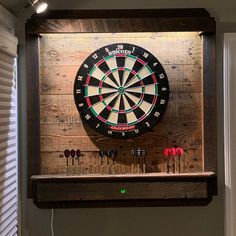 a dart board mounted to the side of a wall with darts on it and other items