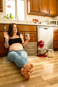 a pregnant woman sitting on the floor with her food