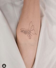 a woman's arm with a butterfly tattoo on the left side of her arm