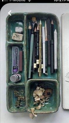 an open green container filled with lots of different types of pencils and other items