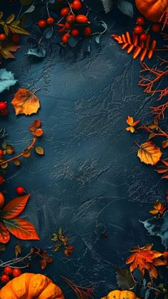 an overhead view of autumn leaves, berries and acorns on a dark background