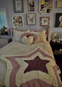 a bedroom with pictures on the wall and a bed covered in a crocheted blanket