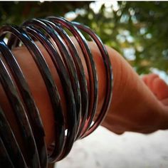 a woman's hand holding several different colored bracelets