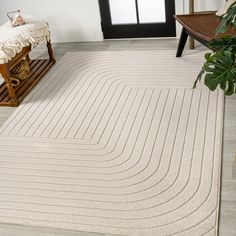 a white rug with wavy lines on it in front of a chair and door way