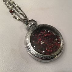 "This is a Stunning antique white gold filled etched pocket watch case Shaker Locket with garnets and tiny pearls inside. The locket has a diameter of approx. 1 3/4\". The chain is a beautiful pearl and garnet rosary chain with a silver chain to accompany. The garnets are various shapes and sizes...round, oval, marquis cuts. The stunning case can be personalized....as there is a place to engrave initials on back....a Gorgeous piece! The chain measures about 22\". The front unscrews if you wish to swap out stones.  A stunning piece with a new life!" Silver Pocket Watch With Locket As Gift, Luxury Silver Locket Necklace As A Gift, Metal Round Pocket Watch Gift, Metal Pocket Watch As Gift, Silver Victorian Pocket Watch Gift, Silver Victorian Pocket Watch For Gift, Elegant Pocket Watch With Locket Pendant, Elegant Round Pendant Pocket Watch With Locket, Timeless Round Pocket Watch As Gift