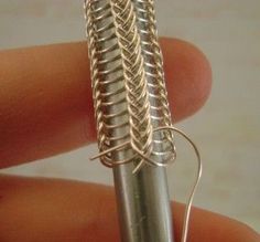 a close up of a person holding a small metal object in their left hand with wire wrapped around it