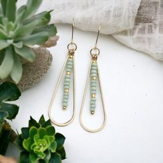 Add a touch of fun and femininity with our Harley gold teardrop earrings, adorned with delicate mint green seed beads. Perfect for any occasion (and any outfit), these long earrings will complete your look and add a hint of whimsy to your style. A must-have for any accessory lover! Approximately 2.25” long Made with 14k Gold Filled Light Mint Green Seed Beads Polished to a high shine Handmade in Montana Sent in a ribboned gift box with polishing cloth Gold Teardrop Earrings, Light Mint Green, African Turquoise, Beach Boho, Jewelry Packaging, Long Earrings, Teardrop Earrings, Boho Jewelry, Mint Green