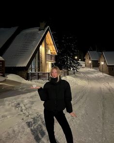 a woman is standing in the snow with her arms out