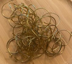 a pile of gold colored metal rings on top of a wooden table