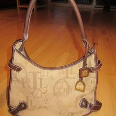 We Have A Pre-Owned Handbag By Ralph Lauren! Canvas And Leather. Magnetic Closure. Horsebit Charm. Zippered And Open Pockets On The Inside. Measures 13.5" At Widest, 10" At Highest Without Strap, Strap Drop Is 10" And Bag Is 3". Some Fading On The Outside Of The Bag As Well As A Few Small Stains. Super Nice And Rare Pre-Owned Handbag By Ralph Lauren! We Have A Smoke Free Home. Please Read The Description And View The Pictures Before Purchasing. Thanks So Much For Stopping By!! **19l** Luxury Ralph Lauren Brown Bags, Luxury Brown Ralph Lauren Shoulder Bag, Brown Leather Ralph Lauren Shoulder Bag, Classic Ralph Lauren Bags With Gold-tone Hardware, Ralph Lauren Shoulder Bag With Gold-tone Hardware For Shopping, Ralph Lauren Handbags, Ralph Lauren Bags, Lauren Brown, Canvas Leather