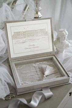 an open box on a table with white ribbons