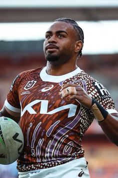 a man holding a rugby ball in his right hand and wearing a jersey with the number 22 on it