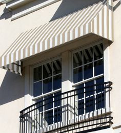 an awning on the side of a building with two windows and balconies