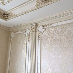 an ornately decorated room with white walls and gold trimmings on the ceiling