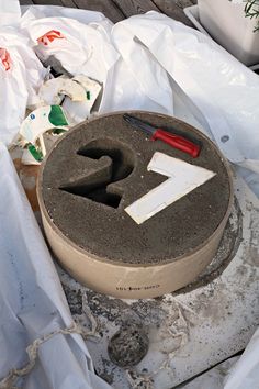 a cement cake sitting on top of a table next to plastic bags and other items