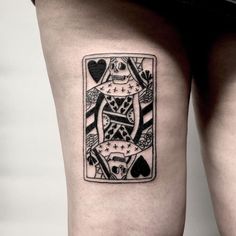 a black and white tattoo on the leg of a woman with a playing card design