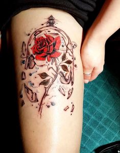 a woman with a rose tattoo on her thigh