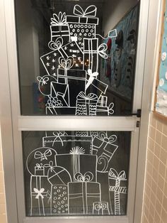 a glass door that has some drawings on it in front of a wall with gifts and presents drawn on it