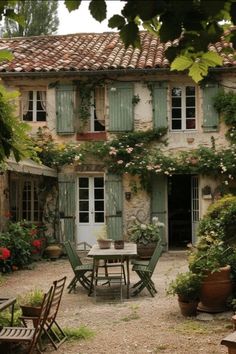 an old stone house with green shutters and potted plants