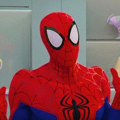 the spider - man is holding his hands up in front of him