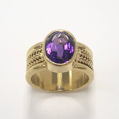 Amethyst ring/03 The playful design is perfect for adding a touch of whimsy to any formal attire, while still maintaining a handsome elegance. Unlike CAD-produced rings made by pouring liquid metal into a mold, this ring is hand-forged from a solid piece of metal. This darling features classic geometric shapes and bold colors. Amethyst's magic intense purple, holding center stage, set in lasting 18 karat gold.  Amethyst: 3.50 ct, 8 x 10 mm   Weight: 13 g      9 mm wide shank Material: 18 karat yellow gold Modern Tanzanite Gemstone Ring, Luxury Purple Ring With Bezel Setting, Elegant Open Amethyst Ring, Elegant Yellow Gold Amethyst Open Ring, Formal Amethyst Jewelry With Polished Finish, Formal Tanzanite Ring With Bezel Setting, Elegant Amethyst Rings With Accent Stones, Elegant Purple Amethyst Bezel Setting Ring, Elegant Amethyst Rings With Gemstone Accents