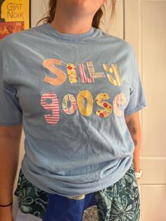 a woman standing in front of a door wearing a t - shirt that says sell loose