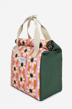 an orange, pink and green bag with white flowers on it's front pocket