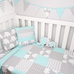 a baby crib with blue and gray bedding